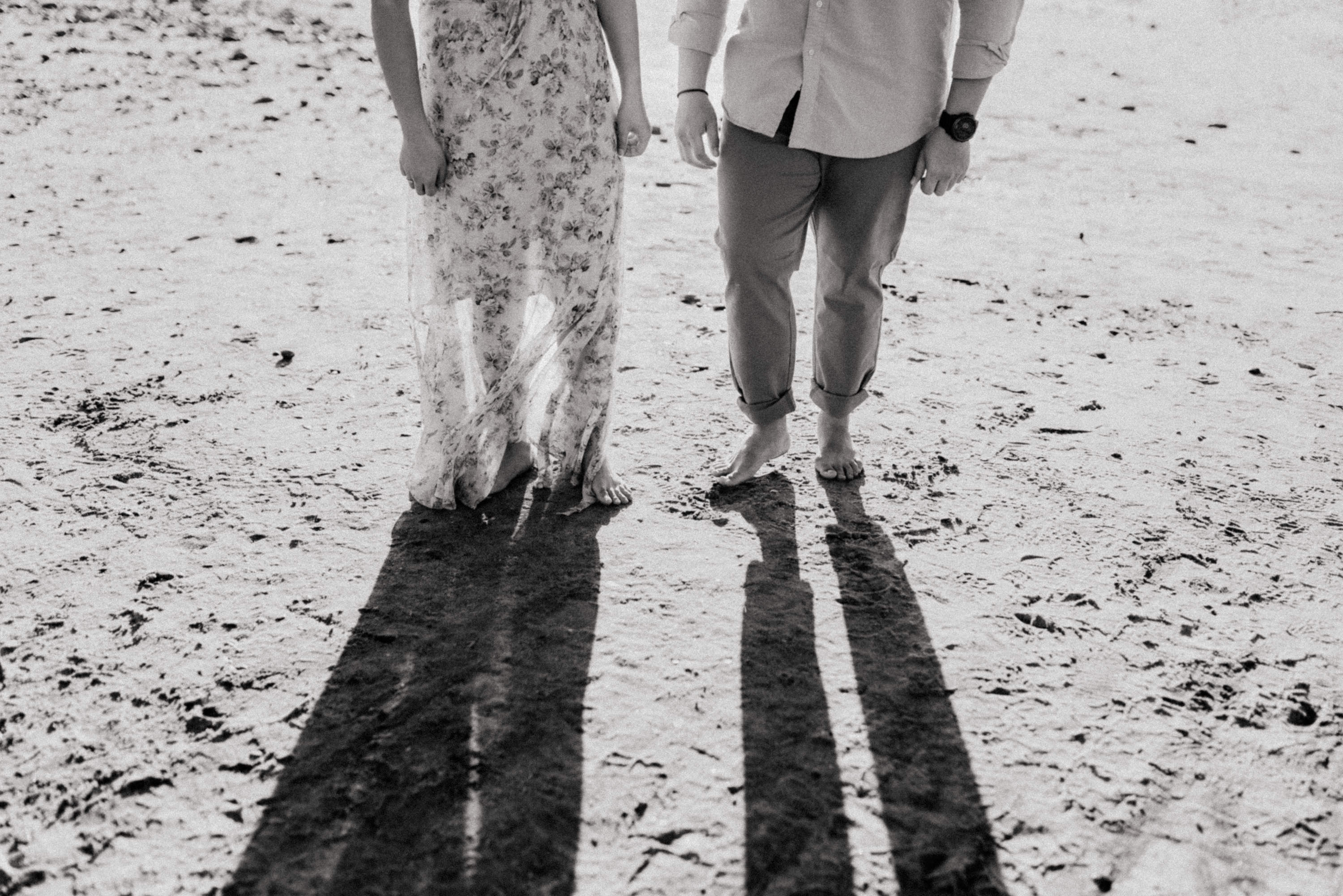 Intimate close-up of the couple's hands on the shoreline for their Torrey Pines beach engagement