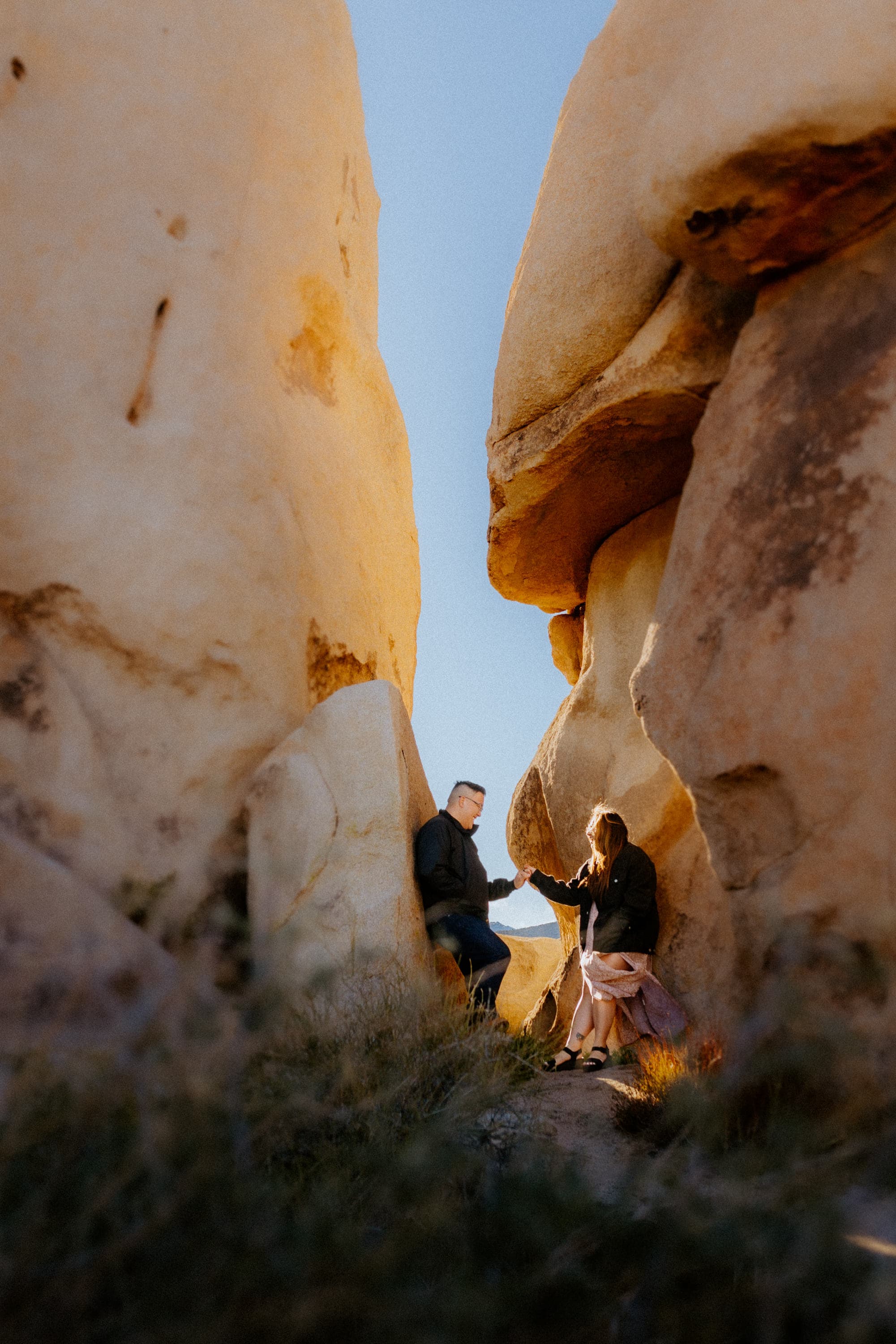 Couple framed by the unique rock formations of Joshua Tree.