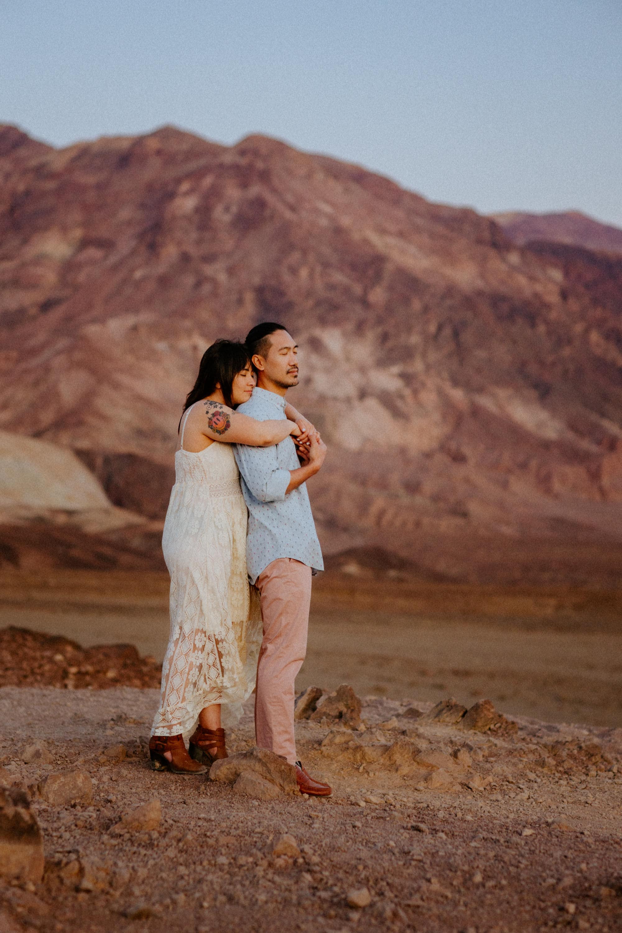Adventurous couple sharing a tender moment amidst the rugged beauty of Death Valley.